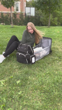 Load and play video in Gallery viewer, Video displaying a diaper bag with a changing station the unfolds in seconds for the baby lay inside. Clips to the stroller and great agronomic fit on the shoulders.